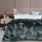 A flannel blanket with a geometric pattern in green and black colors draped over a bed in a room with a modern design.