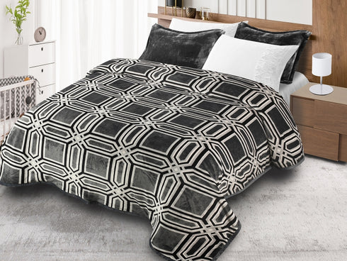 A duvet cover set with a geometric pattern in black, gray, and white colors, displayed on a bed with pillows and a bedsheet.