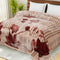 A double bed blanket with a floral pattern in multicolor on a mink background, displayed on a bed.