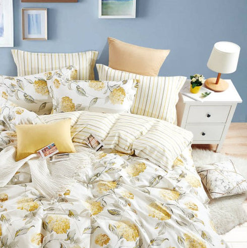 A king size bed sheet set with floral and striped patterns, including two pillow covers, displayed on a bed in a bedroom setting.