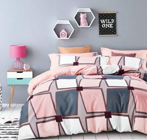 A bedroom scene with a bed having a multicolored geometric patterned top sheet. The room is decorated with pink accents, a nightstand, a lamp, and framed pictures on the wall.