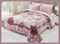 A double bed covered with a purple floral patterned blanket, with matching pillows at the head of the bed, presented as a product listing image.