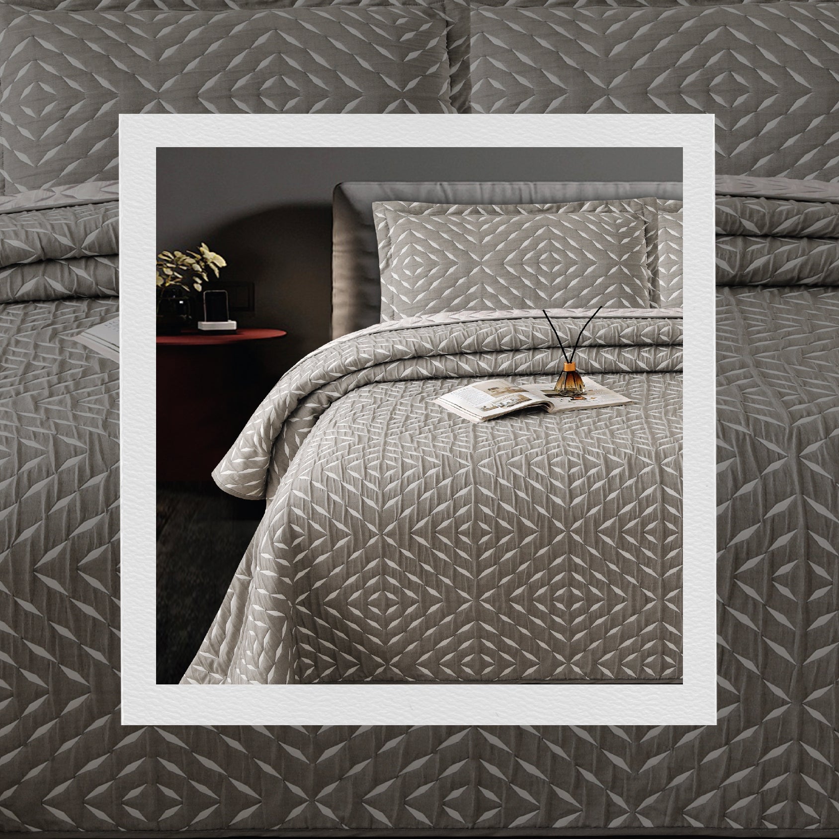 A bed covered with a gray jacquard bedcover set with a geometric pattern, including two pillow covers, in a bedroom setting.