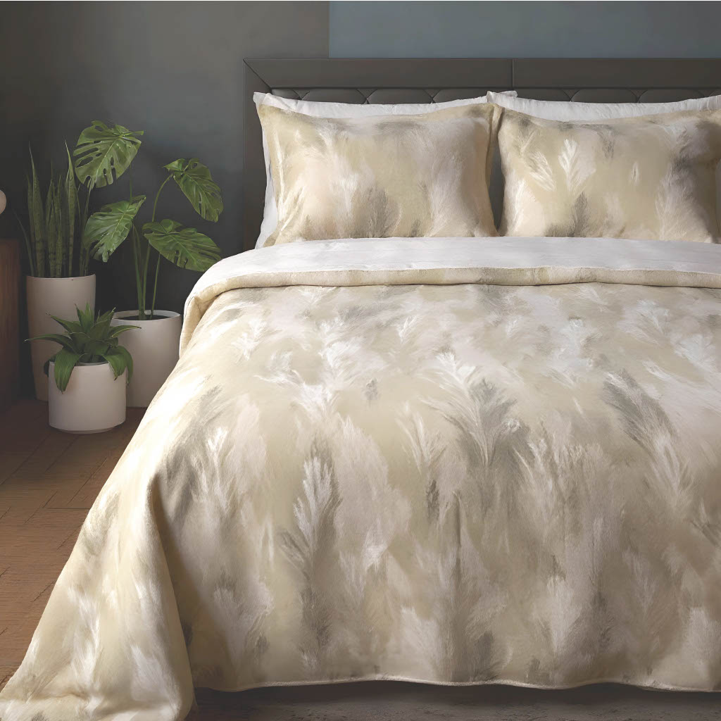 Beige patterned comforter set on a bed with plants in the background