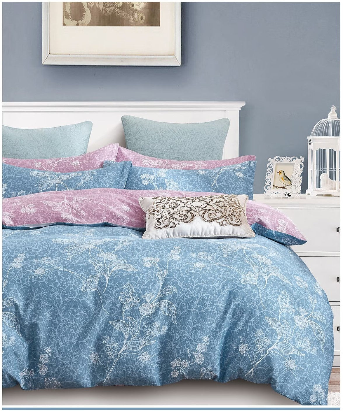 Blue floral bedding set on a bed with decorative pillows in a bedroom setting.